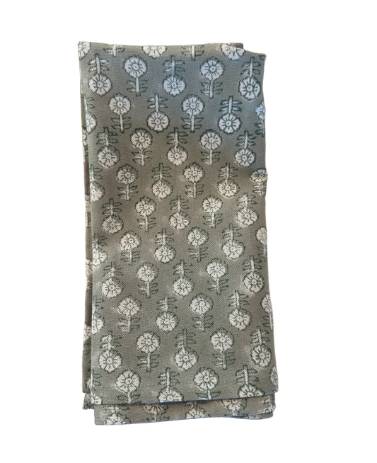 Green floral Patterned napkin on a white plate with a woven placemat