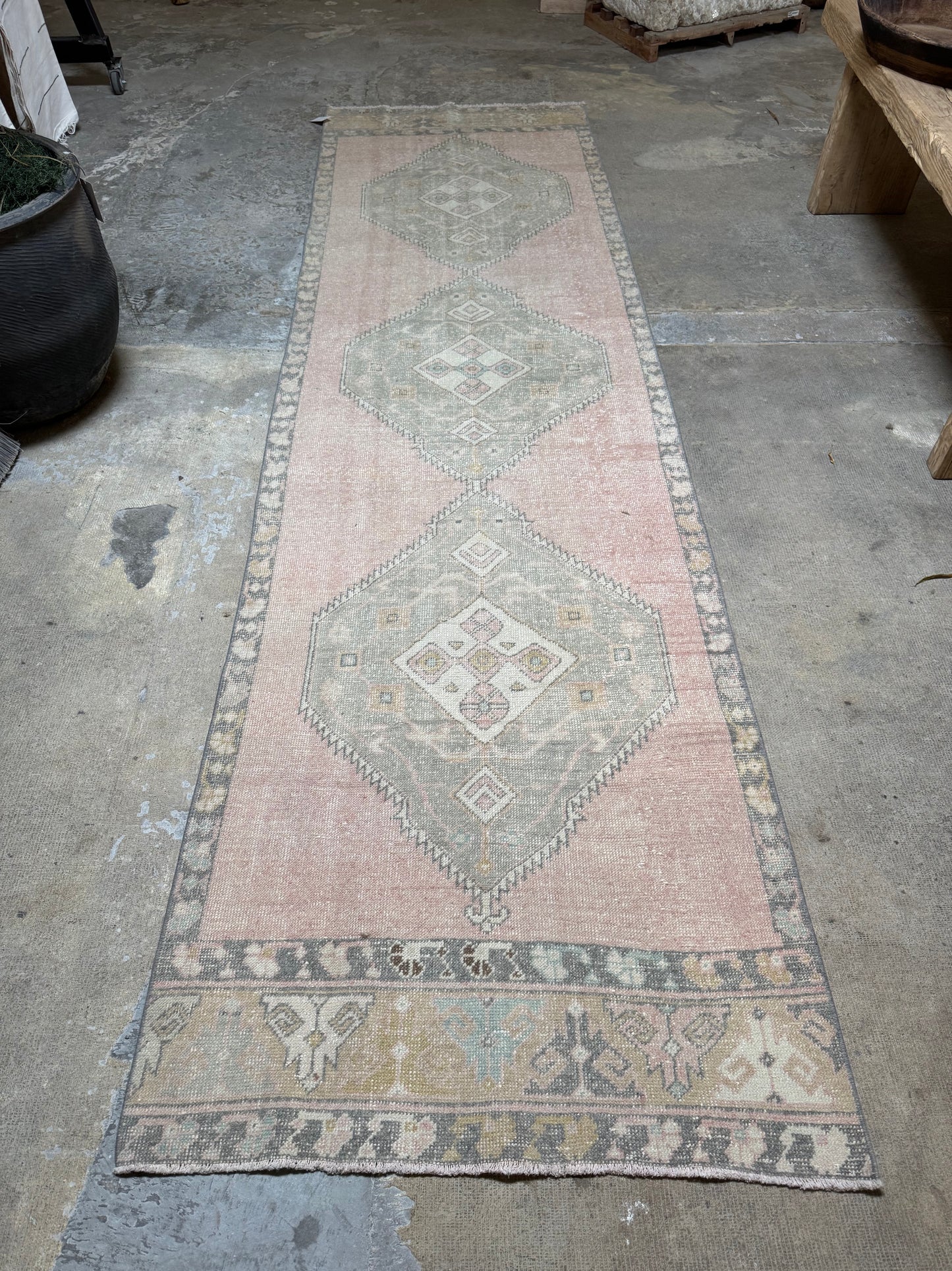 Long, vintaged runner patterned rug on a concrete floor